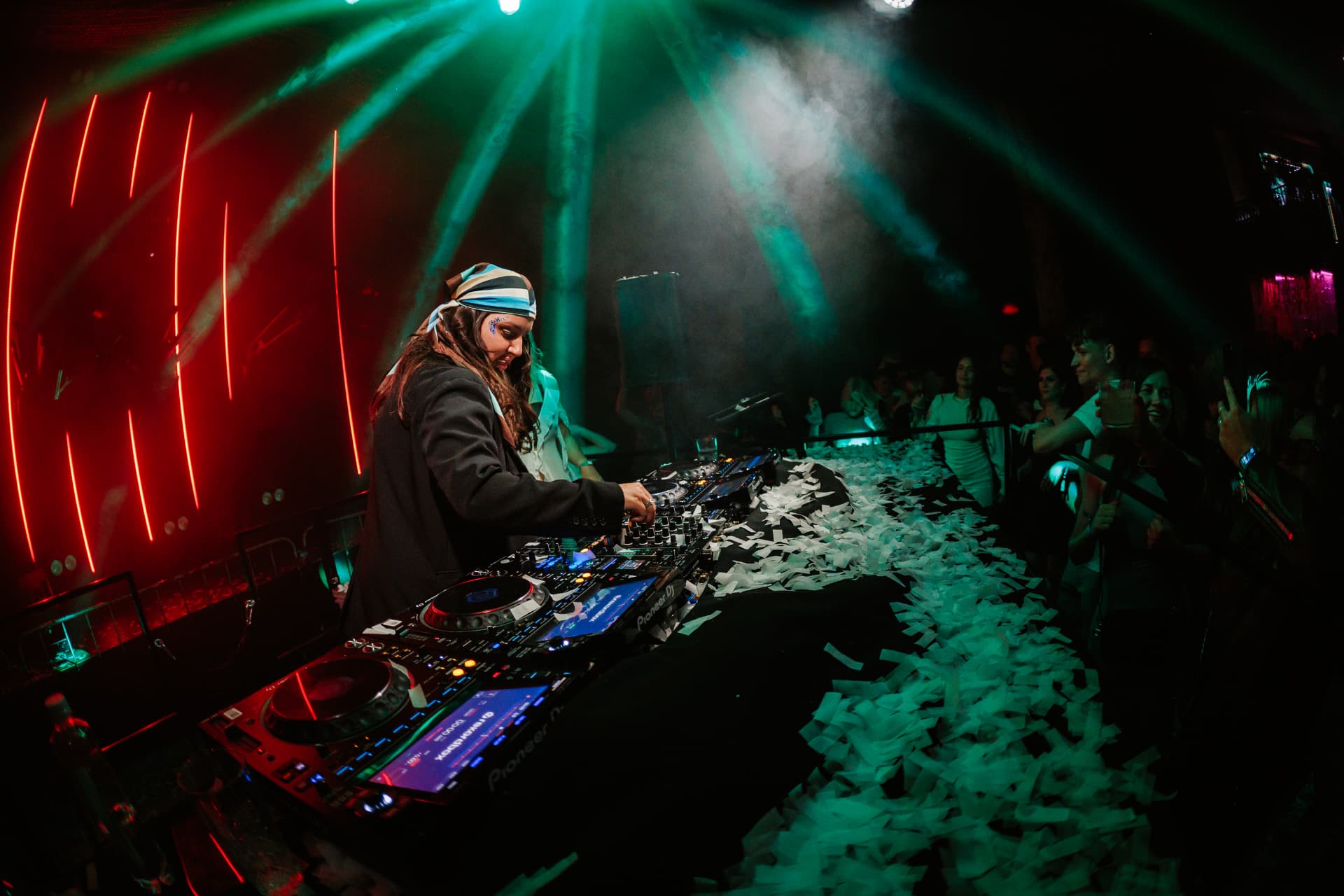DJ performing with confetti and lights at a party
